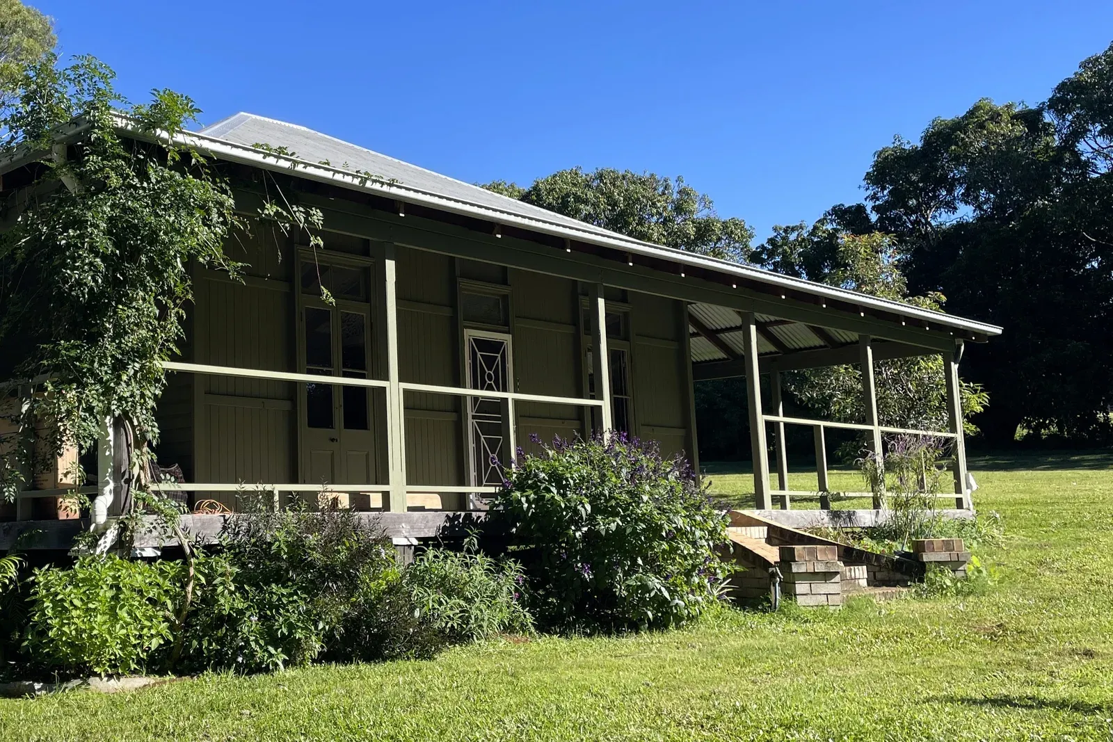 The olive-green weatherboard home at Fernleigh Road after painting