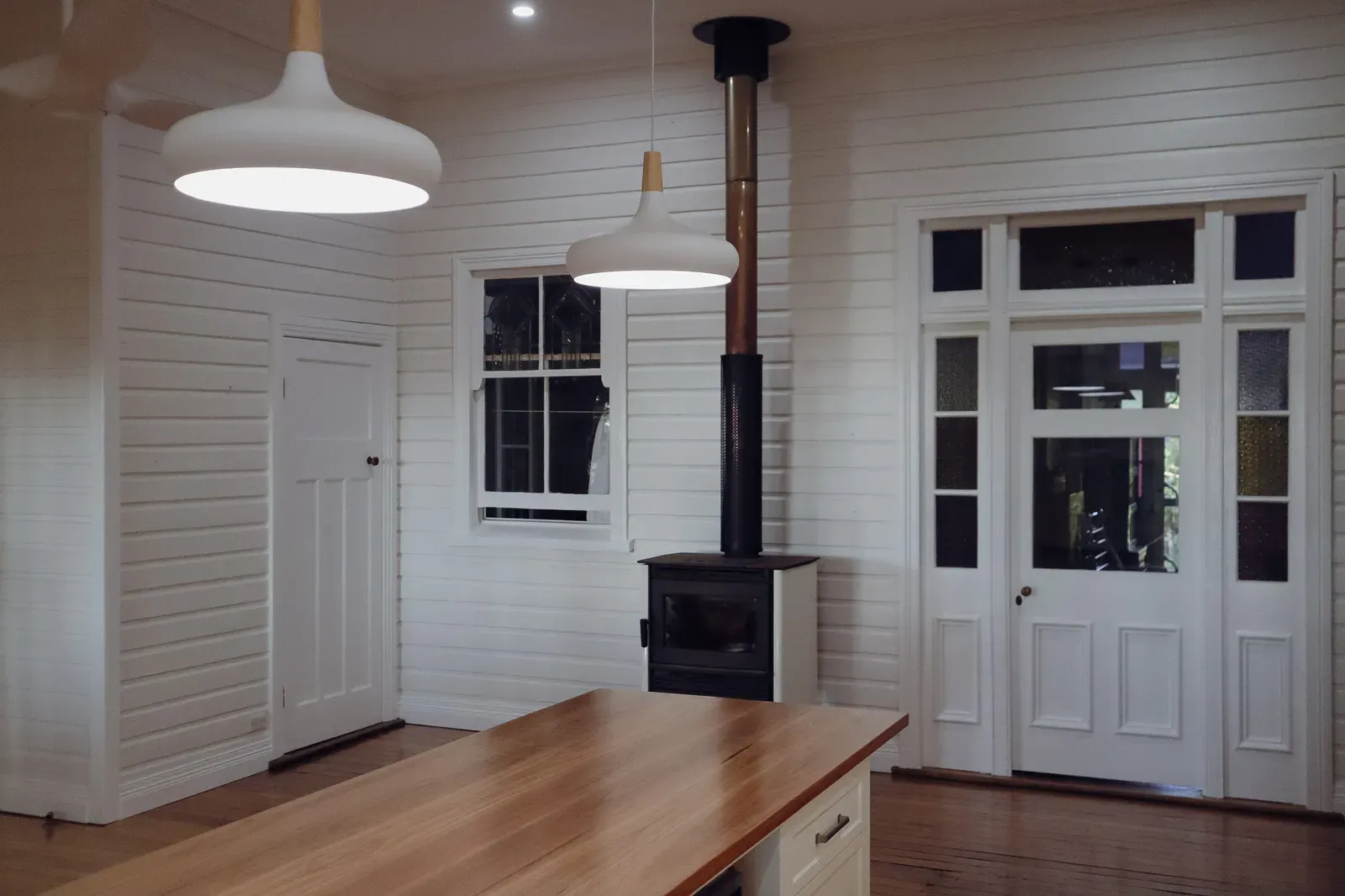 The living area with wood heater and panelled French doors